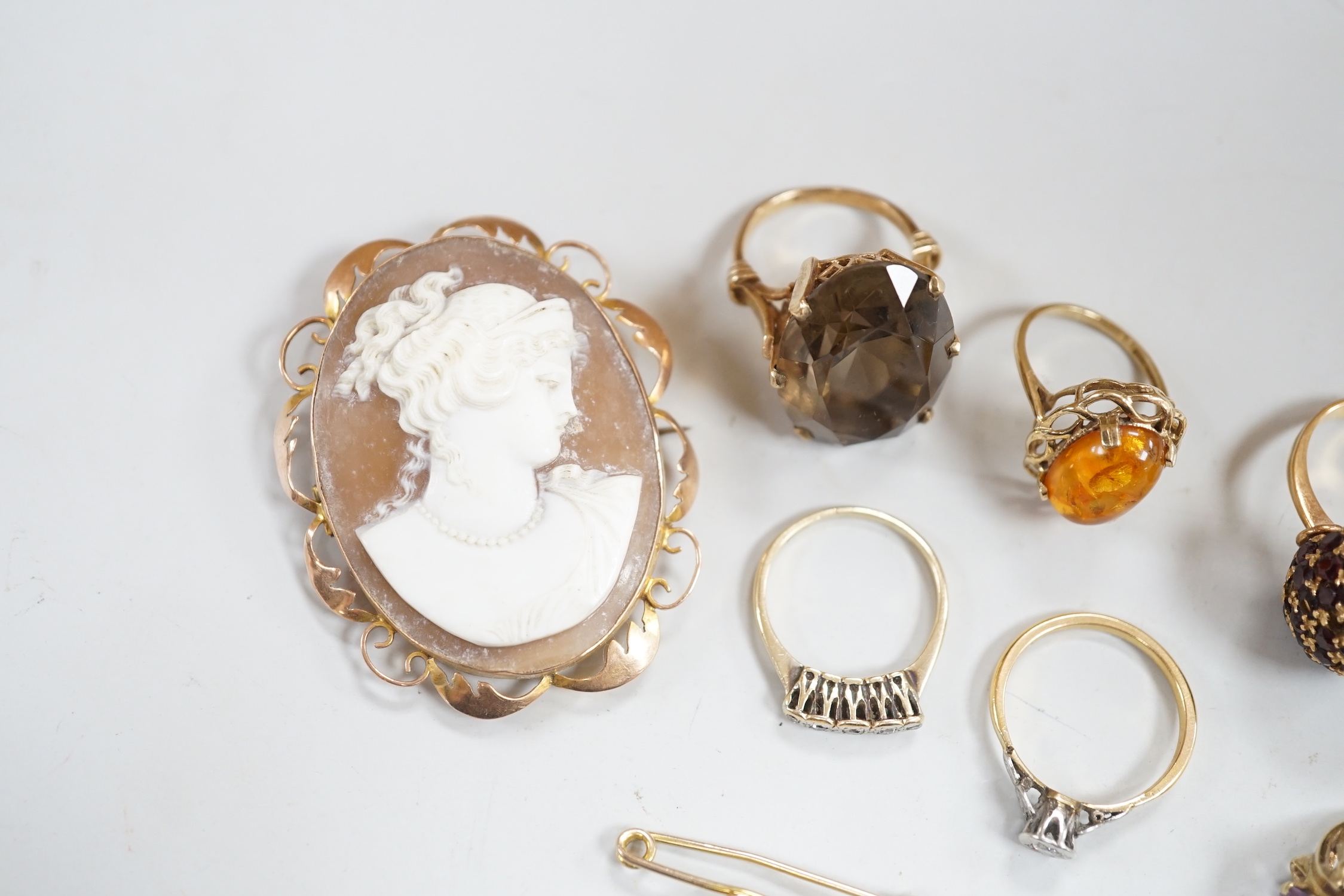 Two yellow metal and illusion set diamond rings, two 9ct gold and gem set rings, two yellow metal and gem set rings and two brooches, including 9ct mounted cameo shell.